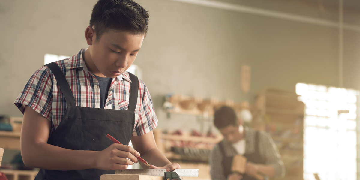 A teenage boy using a tool in shop class | The Boys Education Series